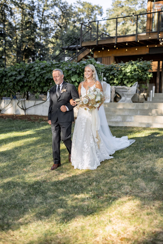 Bride with father walking down aisle entrance at Domaine de Broglie in Dayton, Oregon