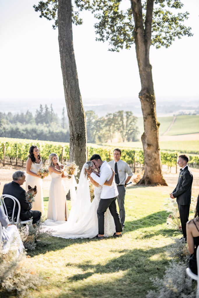 Bride and groom first kiss and dip at Domaine de Broglie winery summer elopement in Dayton, Oregon