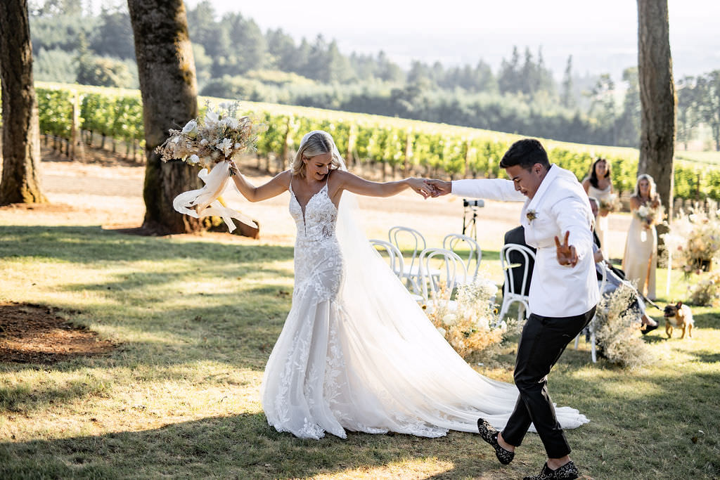 Newlyweds dance down the aisle after ceremony at Domaine de Broglie winery summer elopement in Dayton, Oregon