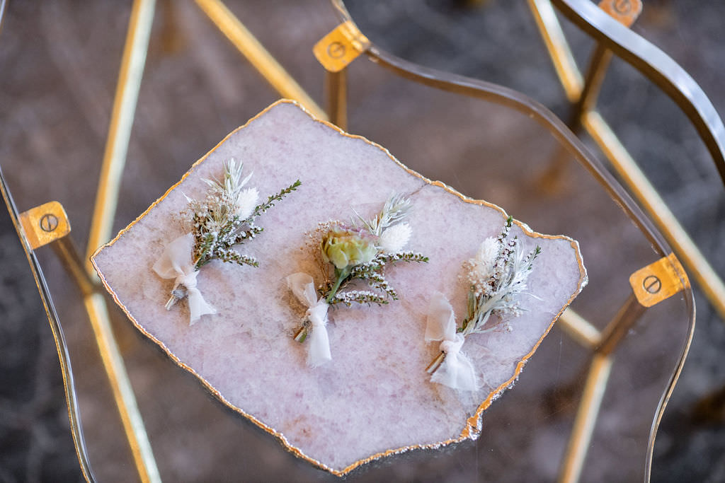 Detail shot of groomsmen's brooches at winery summer elopement