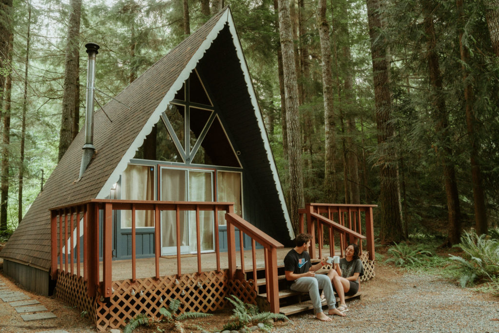 couple sitting in front of a-frame cabin