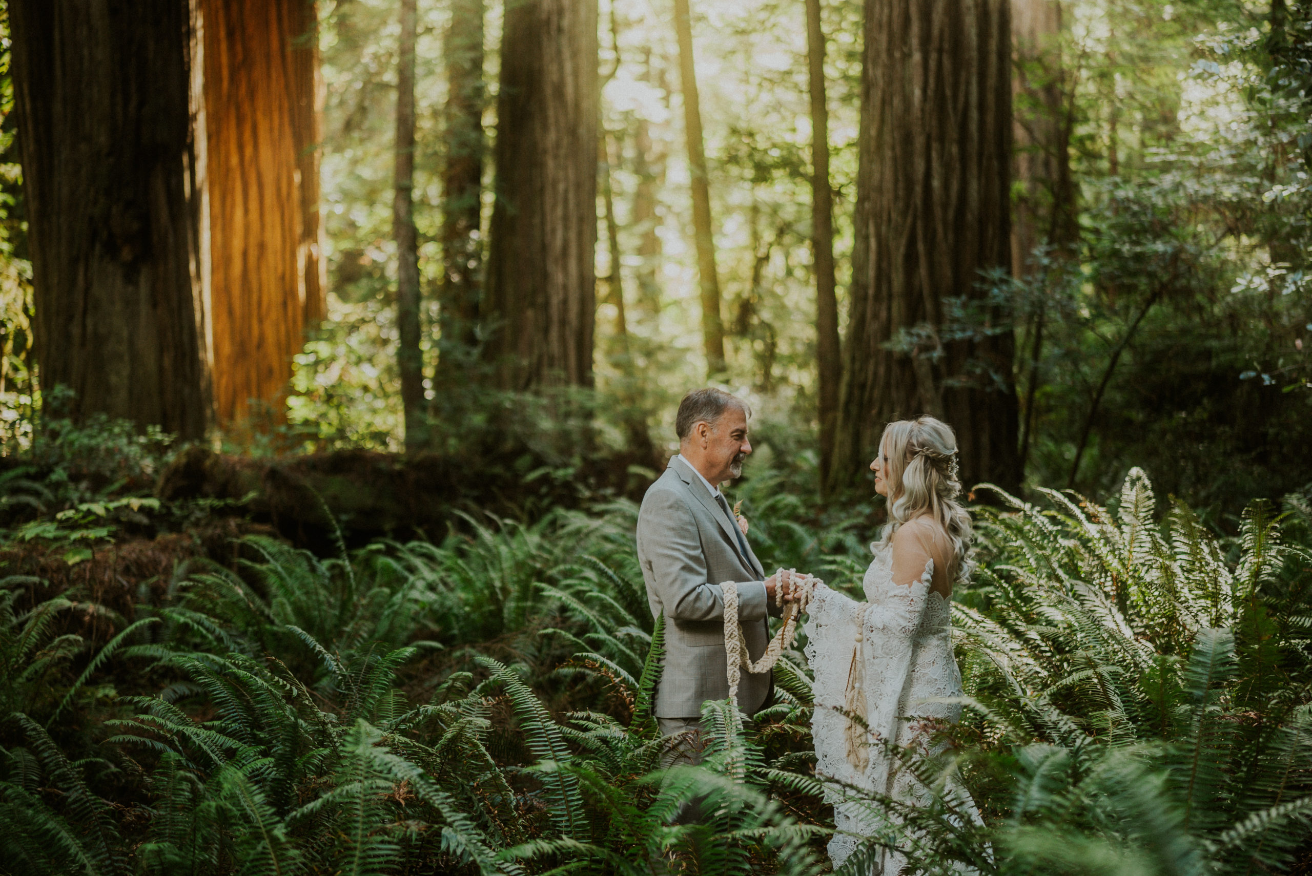 bride and groom standing in forest