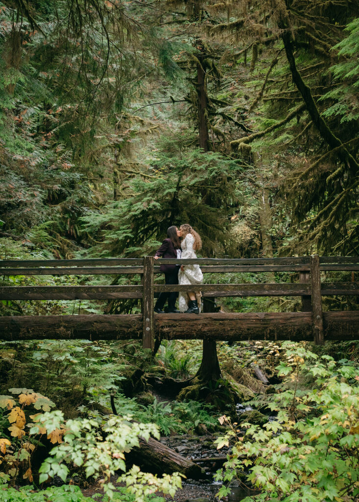 brides kissing on bridge