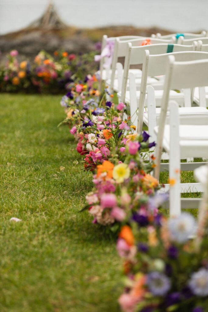 Colorful flower arrangements along aisle of Orcas Island wedding ceremony