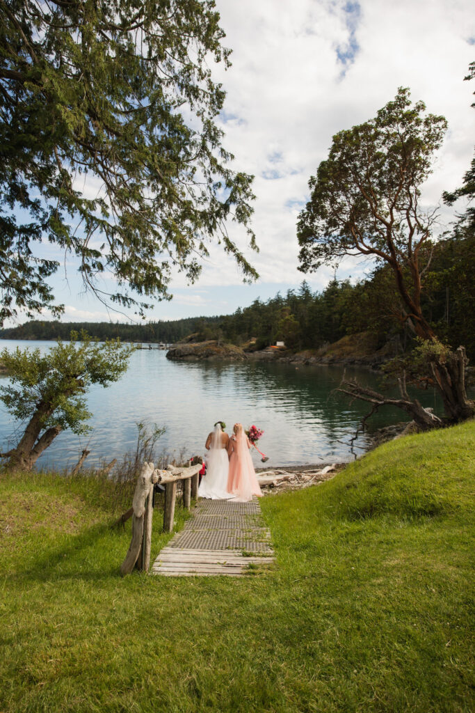 Orcas Island wedding brides walking down wooden pathway towards the ocean