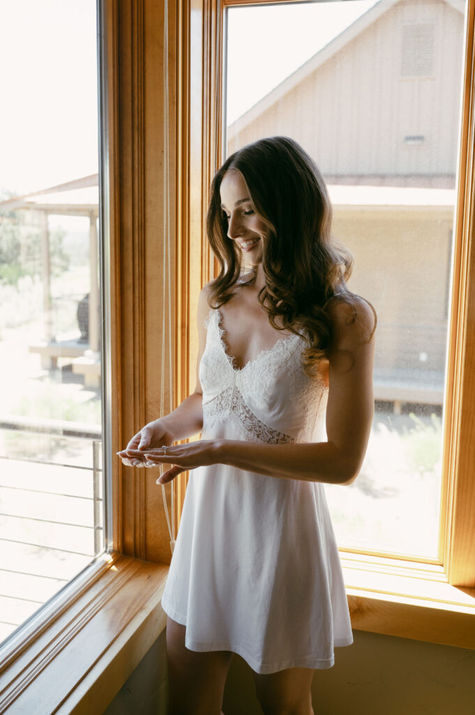 Bridal portrait admiring her ring while getting ready