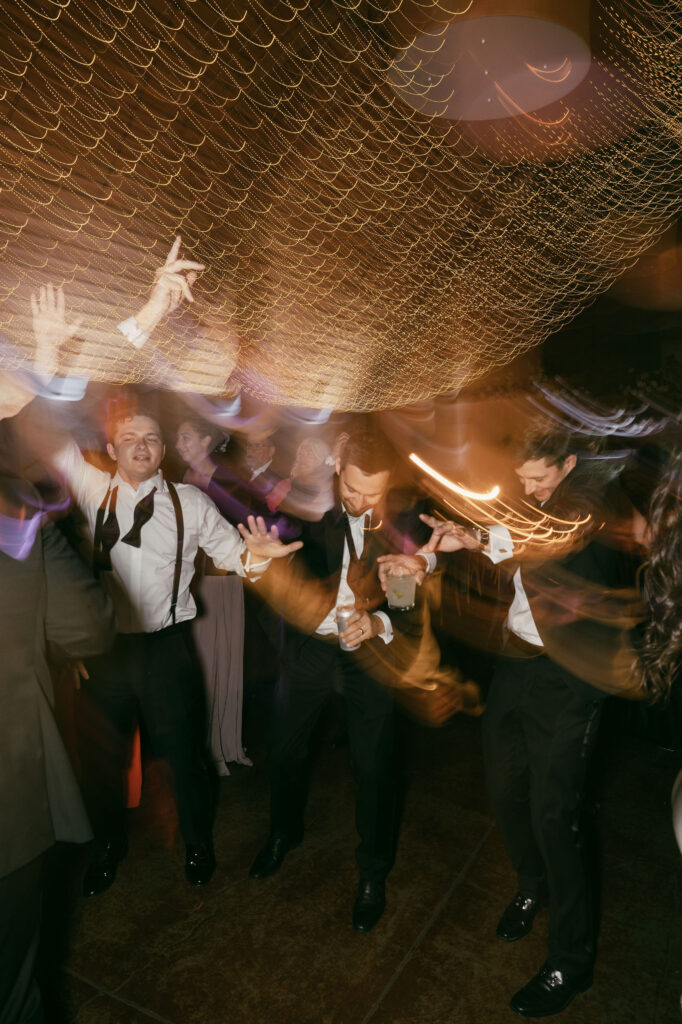 artistic shot wedding guests partying on dancefloor