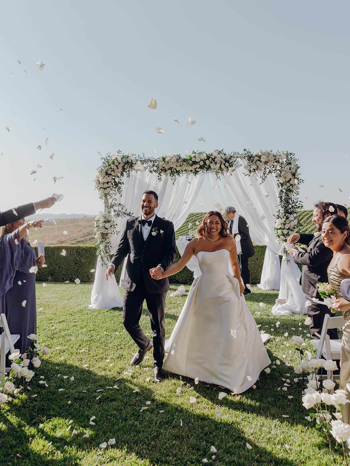 Temecula, CA newlyweds with chuppah in background walking back up the aisle