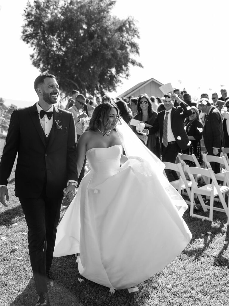 Bride and groom holding hands after Callaway Vineyard & Winery wedding ceremony