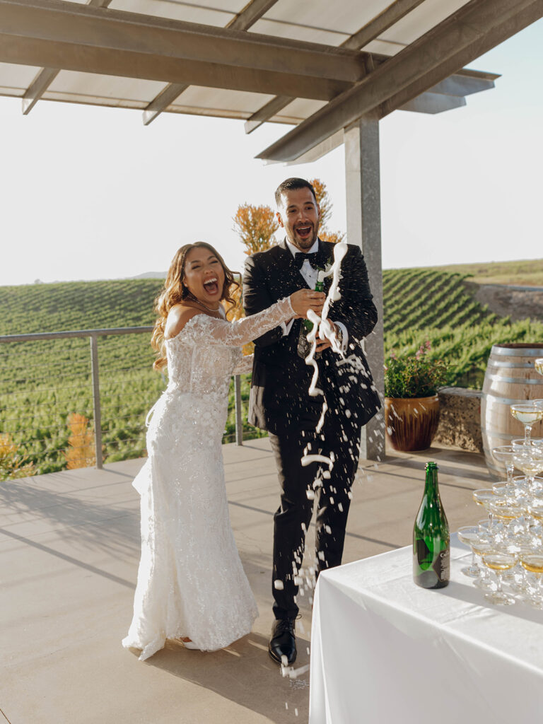 Bride and groom popping champagne during Callaway Winery wedding cocktail hour