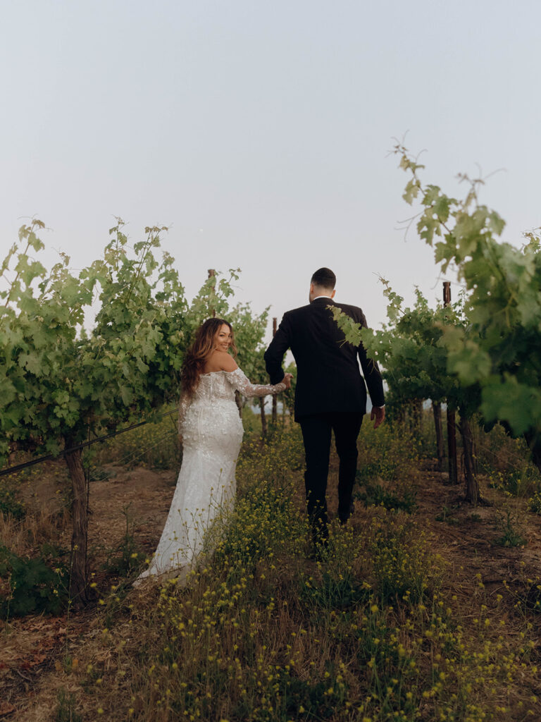 Bride and groom walking away from camera during Callaway Vineyard & Winery wedding sunset portraits