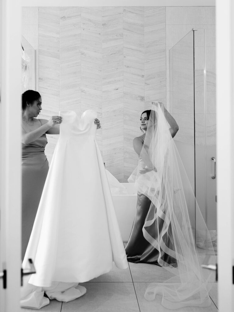 Bridesmaids prepare to help bride into her wedding gown before Callaway Vineyard & Winery wedding