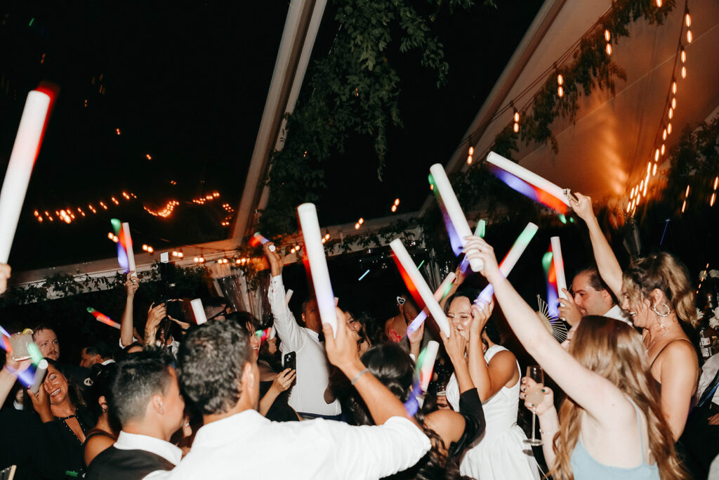 Guests at romantic Griffin House wedding dancing with light up party wands