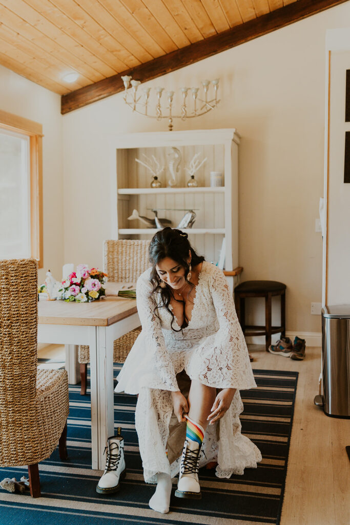 Bride pulling up her rainbow socks before Oregon coast elopement