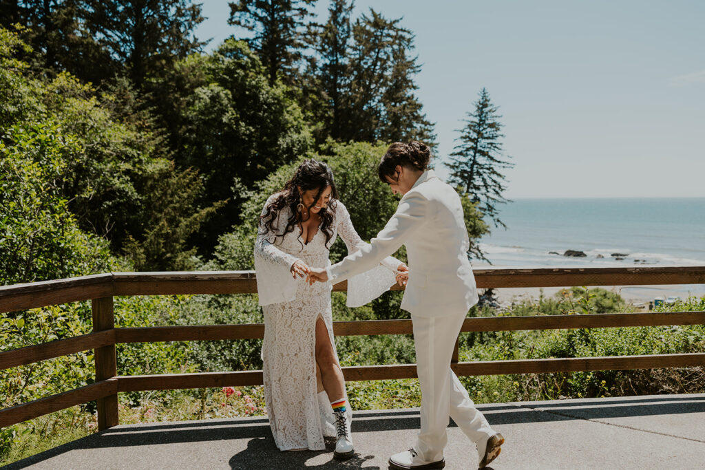 Brides giggling about rainbow socks during redwoods California wedding first look