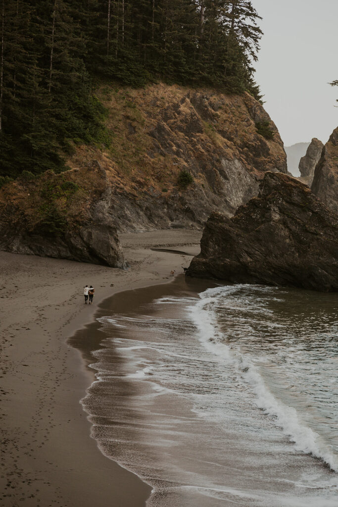 Couple walks along rugged beach before PNW elopement