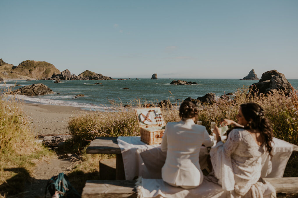 Brides sharing Oregon Coast beach picnic