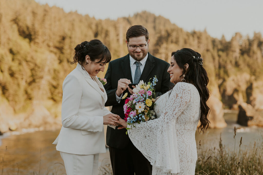 Brides exchanging rings during redwoods California wedding ceremony