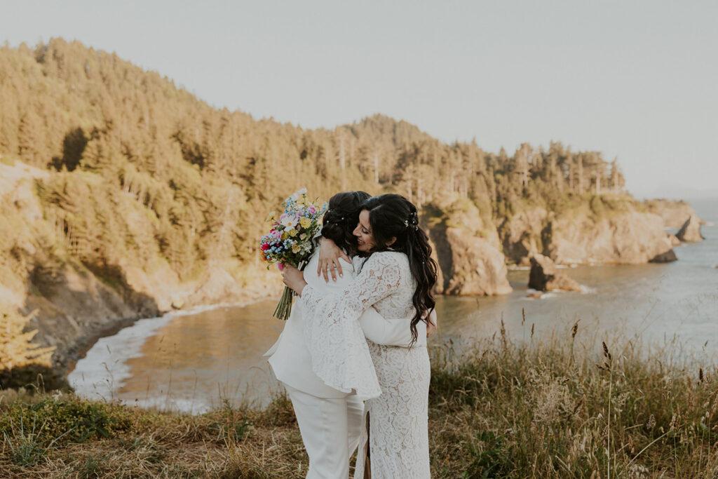 Brides hugging after Oregon coast elopement ceremony