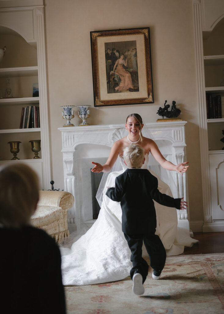 Bride opening arms to hug sons during getting ready photos