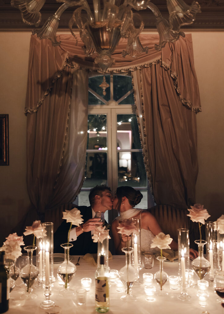 Bride and groom share romantic kiss during intimate candlelit Villa Rinaldi wedding reception