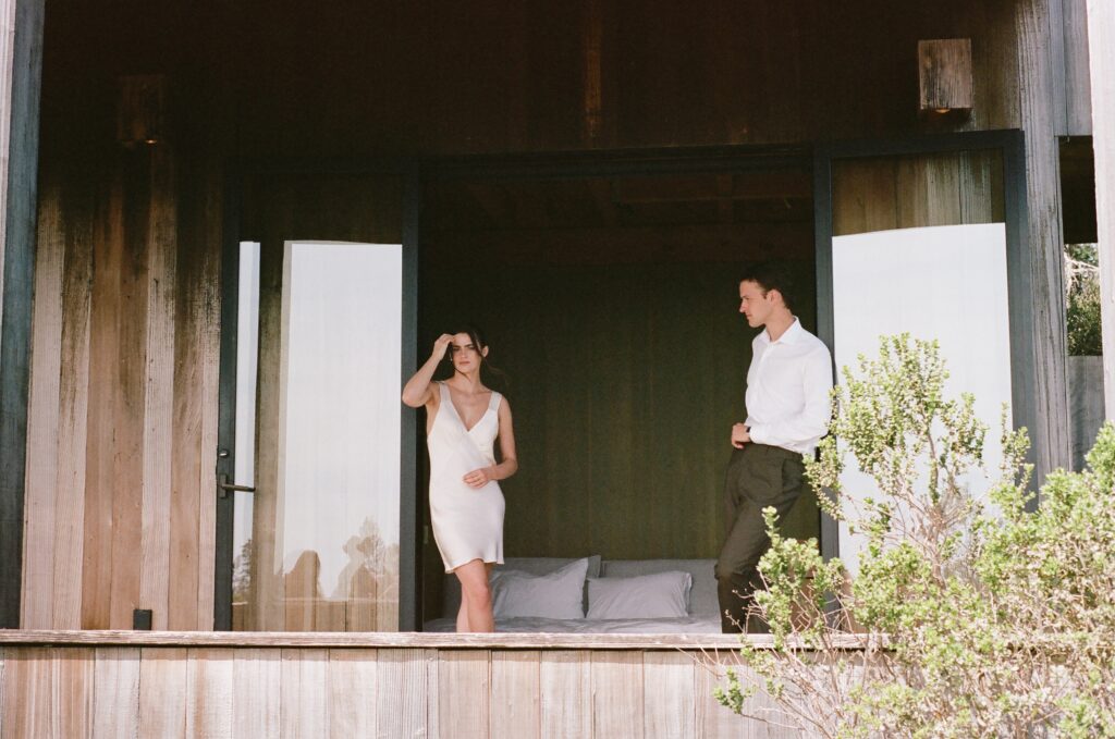 Bride and groom in getting-ready outfits on a private lodge balcony.