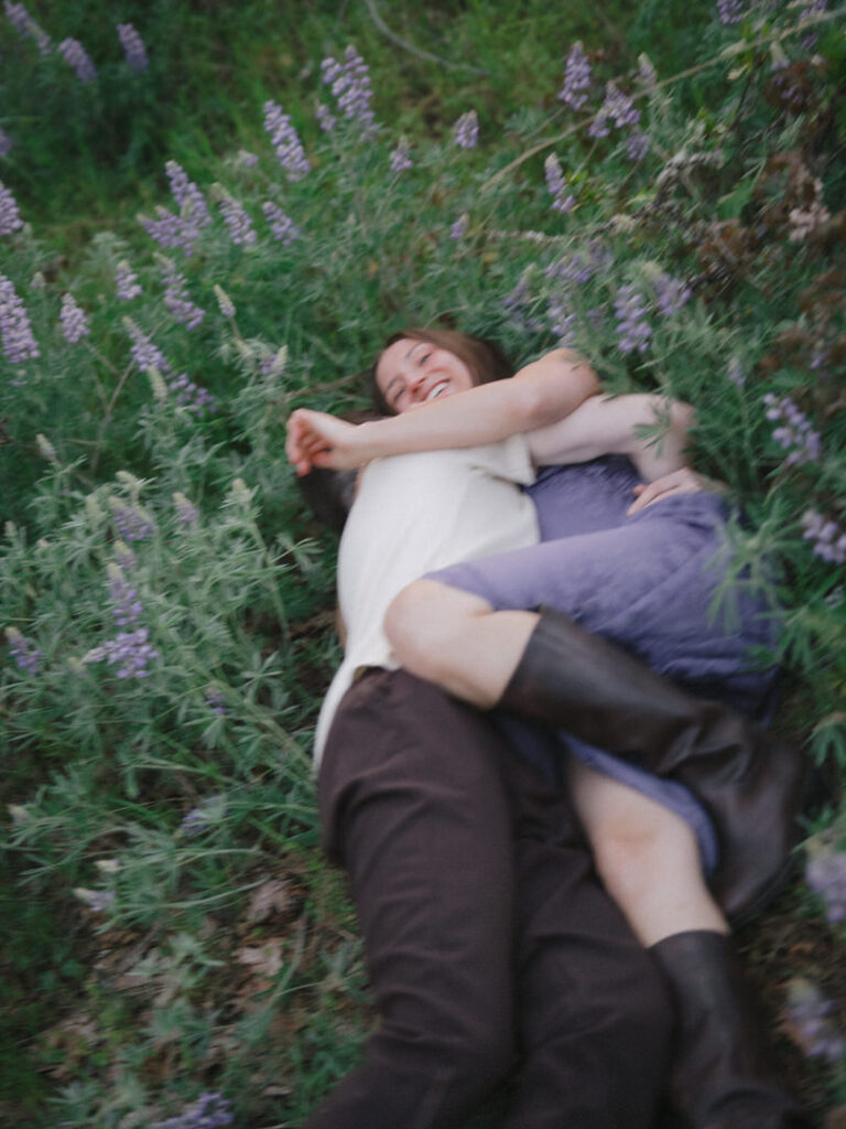 Laughter and cuddles in the lupines during Rowena Crest wildflower engagement.